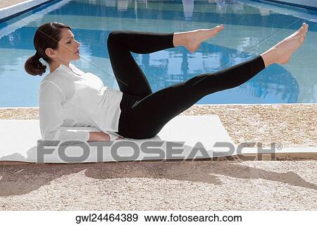 Woman exercising at the poolside View Large Photo Image Stock Photo - Woman exercising at the poolside. Fotosearch