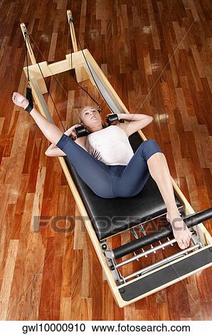 Woman exercising in a gym View Large Photo Image Stock Image - Woman exercising in a gym. Fotosearch