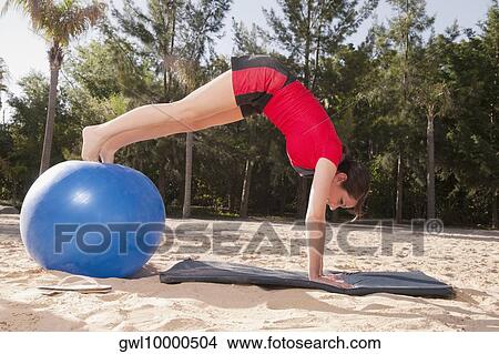 Woman exercising with a fitness ball on the beach View Large Photo Image Picture - Woman exercising with a fitness ball on the beach. Fotosearch