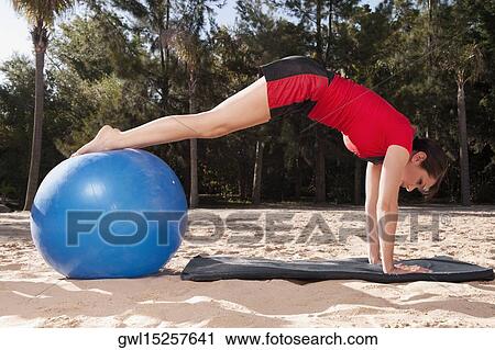 Woman exercising with a fitness ball on the beach View Large Photo Image Stock Image - Woman exercising with a fitness ball on the beach. Fotosearch
