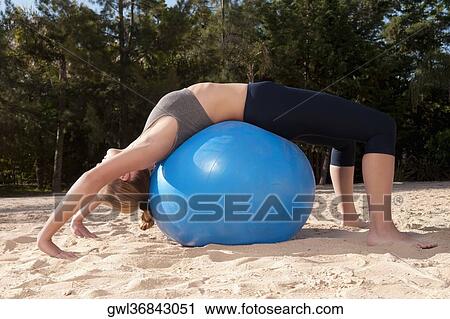 Woman exercising with a fitness ball on the beach View Large Photo Image Stock Image - Woman exercising with a fitness ball on the beach. Fotosearch