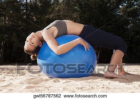 Woman exercising with a fitness ball on the beach View Large Photo Image Stock Image - Woman exercising with a fitness ball on the beach. Fotosearch