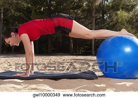 Woman exercising with a fitness ball on the beach View Large Photo Image Stock Photo - Woman exercising with a fitness ball on the beach. Fotosearch