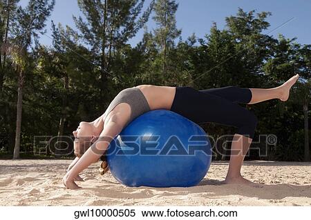 Woman exercising with a fitness ball on the beach View Large Photo Image Stock Photography - Woman exercising with a fitness ball on the beach. Fotosearch