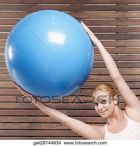 Woman exercising with a fitness ball View Large Photo Image Picture - Woman exercising with a fitness ball. Fotosearch