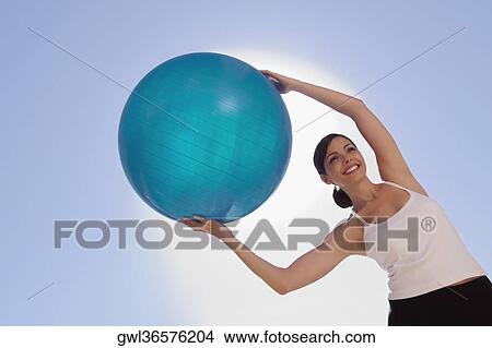 Woman exercising with a fitness ball View Large Photo Image Picture - Woman exercising with a fitness ball. Fotosearch