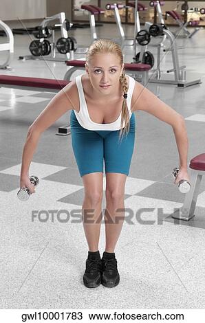 Woman exercising with dumbbells in a gym View Large Photo Image Stock Image - Woman exercising with dumbbells in a gym. Fotosearch