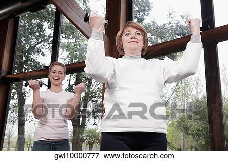 Stock Photo - Woman exercising with her trainer. Fotosearch