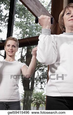 Woman exercising with her trainer View Large Photo Image Stock Photograph - Woman exercising with her trainer. Fotosearch
