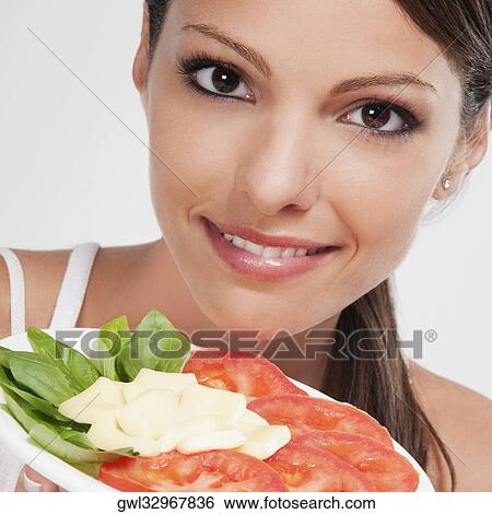 Woman holding a basil with tomato and cheese platter View Large Photo Image Stock Photograph - Woman holding a basil with tomato and cheese platter. Fotosearch
