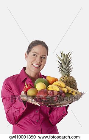 Stock Image - Woman holding a basket of fruits. Fotosearch