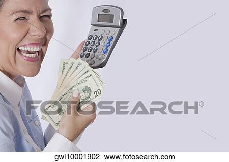 Woman holding a calculator and currency notes View Large Photo Image Stock Image - Woman holding a calculator and currency notes. Fotosearch