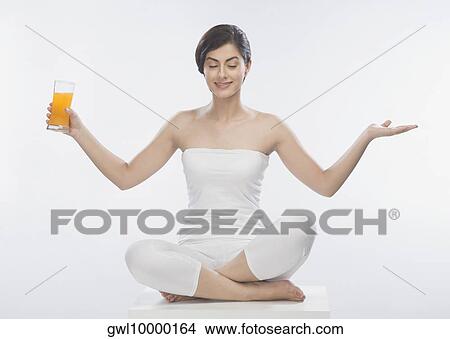 Woman holding a glass of orange juice View Large Photo Image Picture - Woman holding a glass of orange juice. Fotosearch
