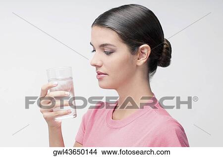 Woman holding a glass of water View Large Photo Image Picture - Woman holding a glass of water. Fotosearch