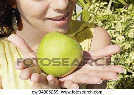 Woman holding a granny smith apple View Large Photo Image Stock Photo - Woman holding a granny smith apple. Fotosearch