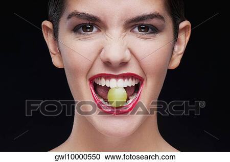 Woman holding a green grape between her teeth View Large Photo Image Stock Image - Woman holding a green grape between her teeth. Fotosearch