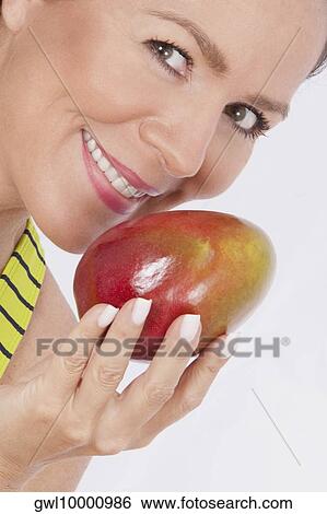 Woman holding a mango View Large Photo Image Stock Photograph - Woman holding a mango. Fotosearch