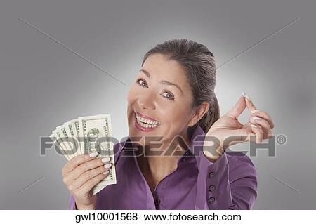 Woman holding a pill and currency notes View Large Photo Image Stock Photo - Woman holding a pill and currency notes. Fotosearch