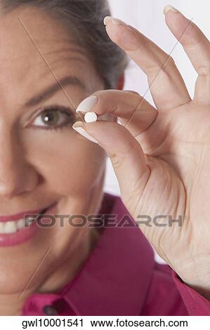 Woman holding a pill View Large Photo Image Stock Image - Woman holding a pill. Fotosearch