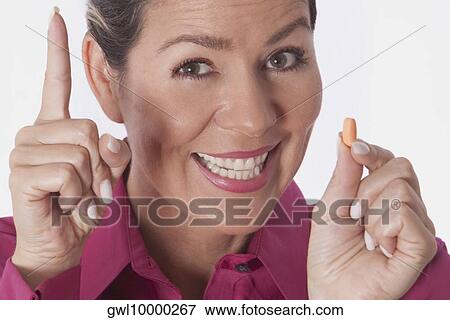 Woman holding a pill View Large Photo Image Stock Photo - Woman holding a pill. Fotosearch