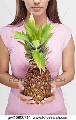 Picture - Woman holding a pineapple. Fotosearch