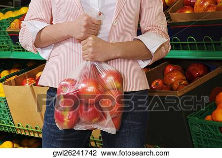 Woman holding a plastic bag of apples View Large Photo Image Stock Image - Woman holding a plastic bag of apples. Fotosearch