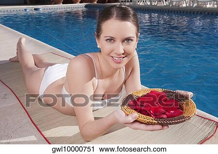 Woman holding a plate of rose petals at the poolside View Large Photo Image Stock Image - Woman holding a plate of rose petals at the poolside. Fotosearch