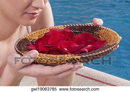 Woman holding a plate of rose petals at the poolside View Large Photo Image Stock Photography - Woman holding a plate of rose petals at the poolside. Fotosearch