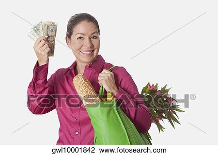 Woman holding a shopping bag of groceries and showing currency notes View Large Photo Image Stock Image - Woman holding a shopping bag of groceries and showing currency notes. Fotosearch