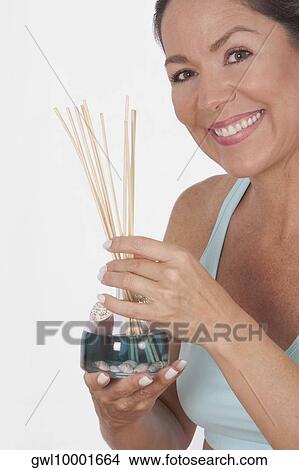 Woman holding an aromatherapy oil bottle with incenses View Large Photo Image Picture - Woman holding an aromatherapy oil bottle with incenses. Fotosearch