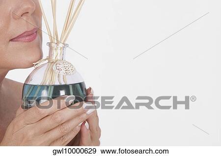 Woman holding an aromatherapy oil bottle with incenses View Large Photo Image Stock Photo - Woman holding an aromatherapy oil bottle with incenses. Fotosearch