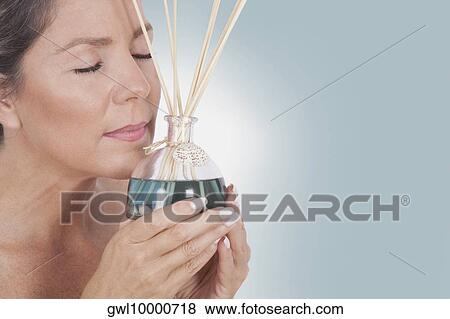 Woman holding an aromatherapy oil bottle with incenses View Large Photo Image Stock Photo - Woman holding an aromatherapy oil bottle with incenses. Fotosearch