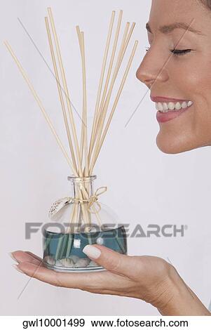 Woman holding an aromatherapy oil bottle with incenses View Large Photo Image Stock Photo - Woman holding an aromatherapy oil bottle with incenses. Fotosearch