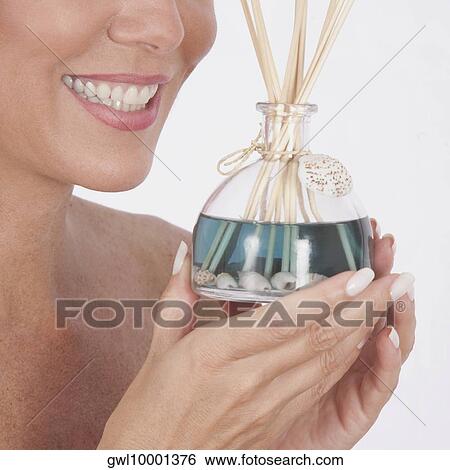 Woman holding an aromatherapy oil bottle with incenses View Large Photo Image Stock Photograph - Woman holding an aromatherapy oil bottle with incenses. Fotosearch