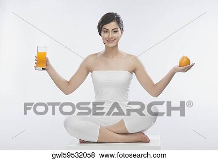 Woman holding an orange and a glass of orange juice View Large Photo Image Stock Photo - Woman holding an orange and a glass of orange juice. Fotosearch