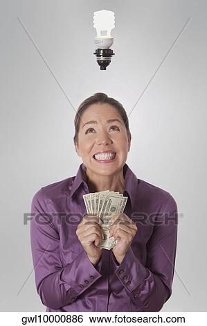 Stock Photograph - Woman holding currency notes. Fotosearch