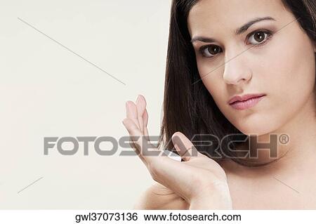 Stock Photograph - Woman holding moisturizer cream on her palm. Fotosearch