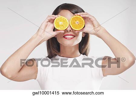 Woman holding orange halves over her eyes View Large Photo Image Stock Photography - Woman holding orange halves over her eyes. Fotosearch