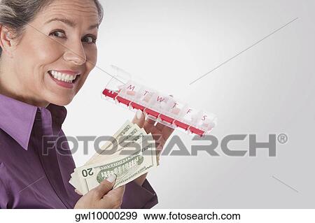 Woman holding pills box and currency notes View Large Photo Image Stock Photo - Woman holding pills box and currency notes. Fotosearch