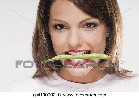 Woman holding stalk of bean between her teeth View Large Photo Image Stock Image - Woman holding stalk of bean between her teeth. Fotosearch