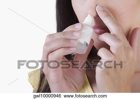 Woman inhaling nasal spray View Large Photo Image Stock Photograph - Woman inhaling nasal spray. Fotosearch