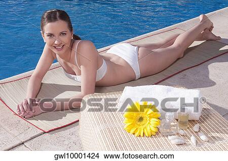 Woman lying at the poolside View Large Photo Image Picture - Woman lying at the poolside. Fotosearch