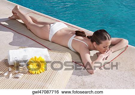 Woman lying at the poolside View Large Photo Image Stock Photograph - Woman lying at the poolside. Fotosearch