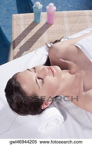 Woman lying on a massage table with bath salt bottles View Large Photo Image Stock Photography - Woman lying on a massage table with bath salt bottles. Fotosearch