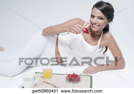 Woman lying on the floor and eating strawberries View Large Photo Image Stock Image - Woman lying on the floor and eating strawberries. Fotosearch
