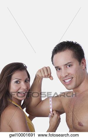 Woman measuring biceps of a man with a tape measure View Large Photo Image Stock Image - Woman measuring biceps of a man with a tape measure. Fotosearch