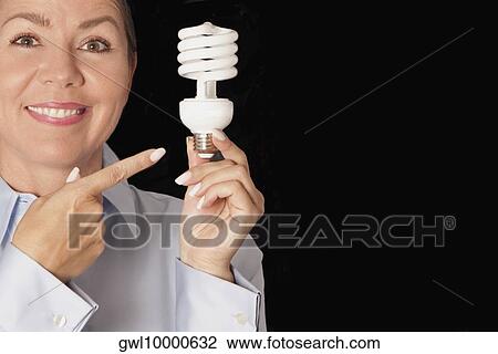 Woman pointing toward a compact fluorescent light bulb View Large Photo Image Stock Image - Woman pointing toward a compact fluorescent light bulb. Fotosearch