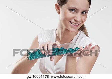Stock Photo - Woman pouring bath beads on her palm. Fotosearch