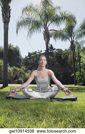 Woman practicing yoga in a park View Large Photo Image Stock Photo - Woman practicing yoga in a park. Fotosearch