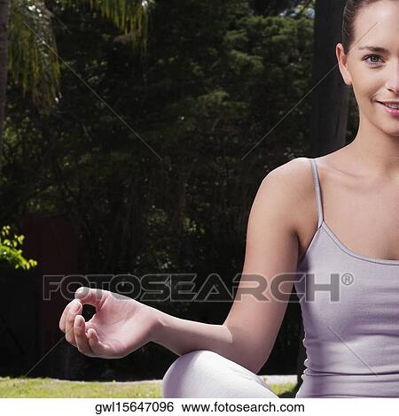 Woman practicing yoga in a park View Large Photo Image Stock Photograph - Woman practicing yoga in a park. Fotosearch